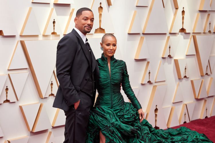 Will Smith com terno preto e Jada Smith com vestido longo verde no tapete vermelho, Oscar 2022
