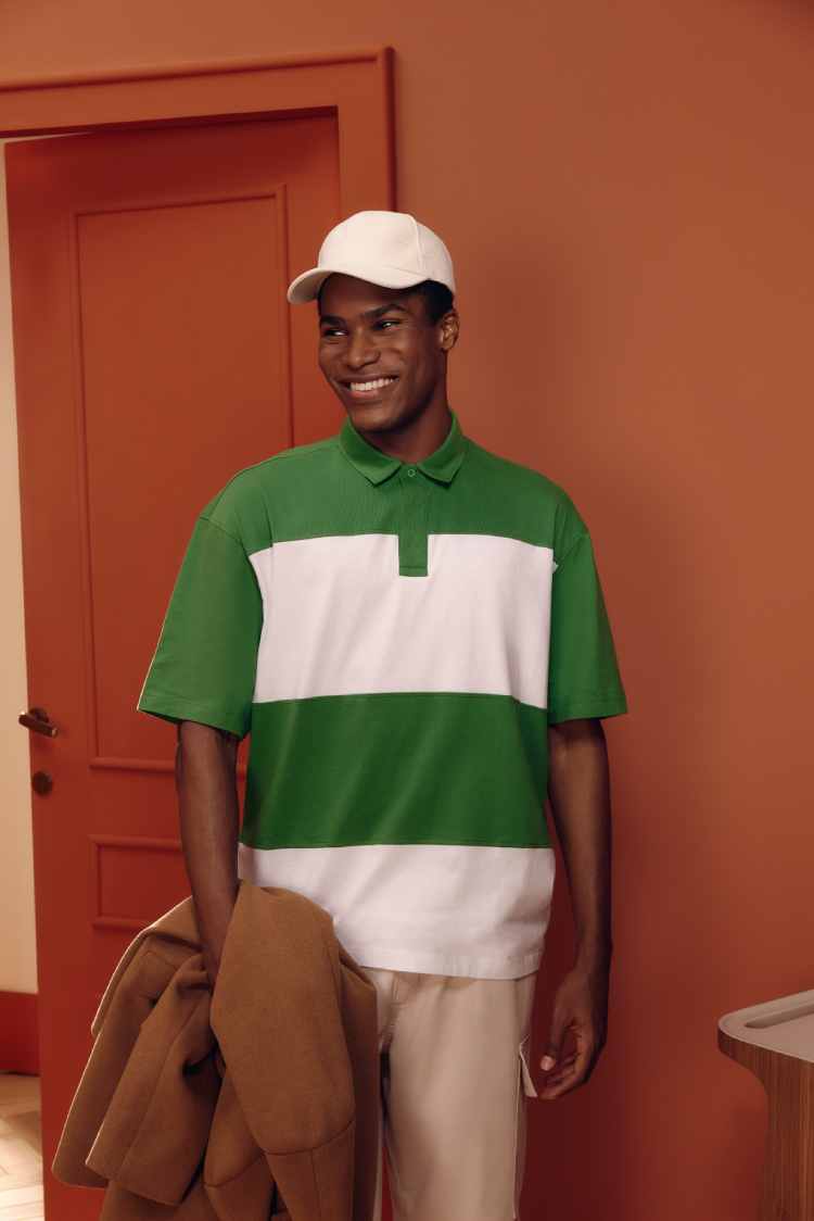 homem com camiseta listrada verde e branca e boné branco