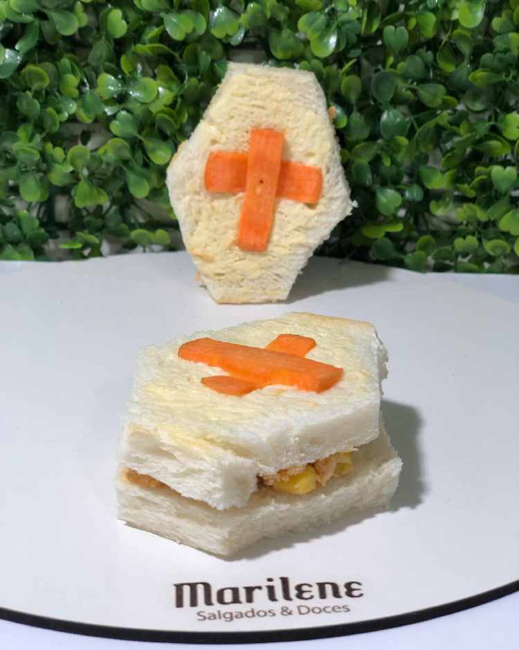 pão de forma em formato de caixão e decoração de cruz feita de cenoura