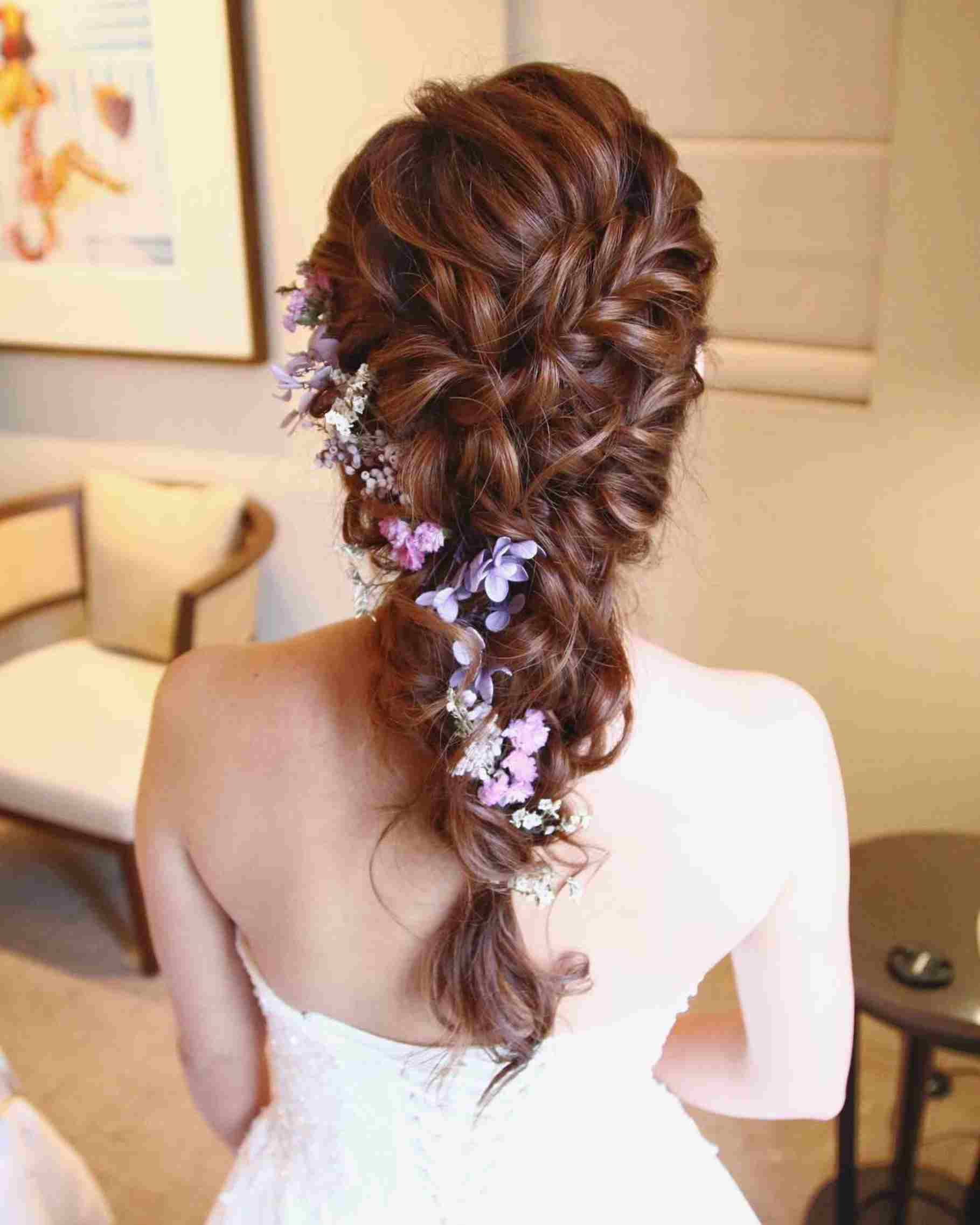 foto de noiva de costas com penteado de trança embutida e flores na lateral