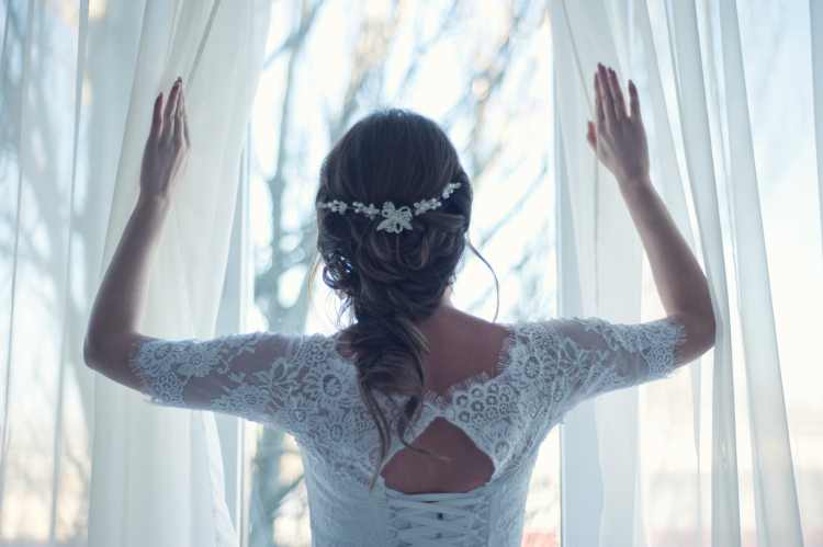 Noiva de costas abrindo cortina