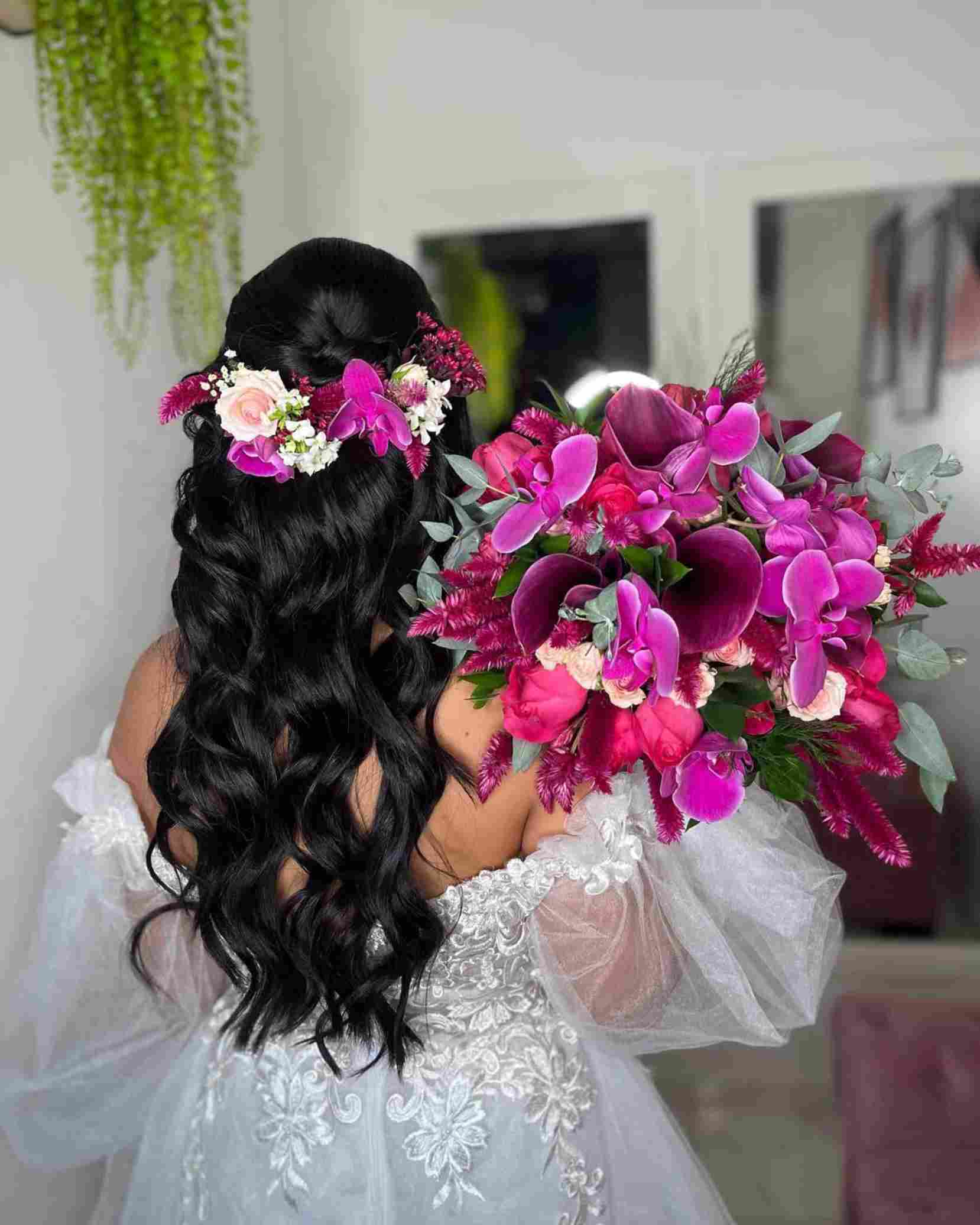 noiva de costas com cabelo preto meio preso e detalhe de flores coloridas