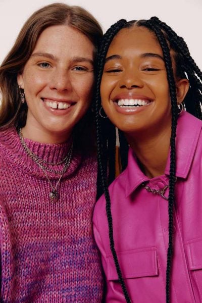 duas mulheres sorrindo com roupa rosa