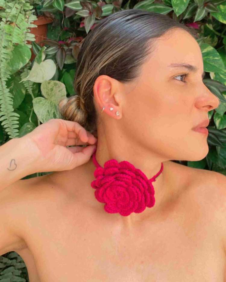 mulher com choker de flor de tricô rosa no pescoço