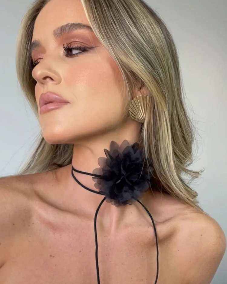 mulher com choker de flor preta no pescoço