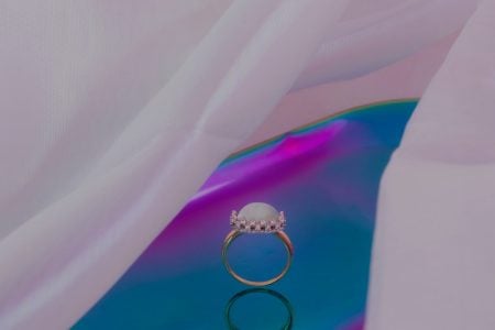 foto de anel em fundo branco, roxo e azul