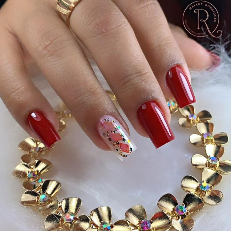 Tipos de alongamentos de unhas: unhas acrílicas, decoradas com glitter dourado e esmaltação vermelha