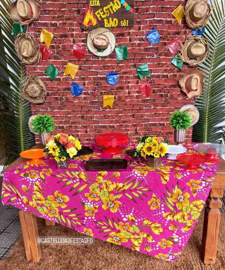 Decoração simples para arraiá: toalhada de mesa, arranjos de flores, bandeirolas, chapéu de palha, etc