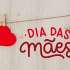 Montagem de fundo de madeira com varal de um coração e frase "Dia das Mães" em vermelho com coração