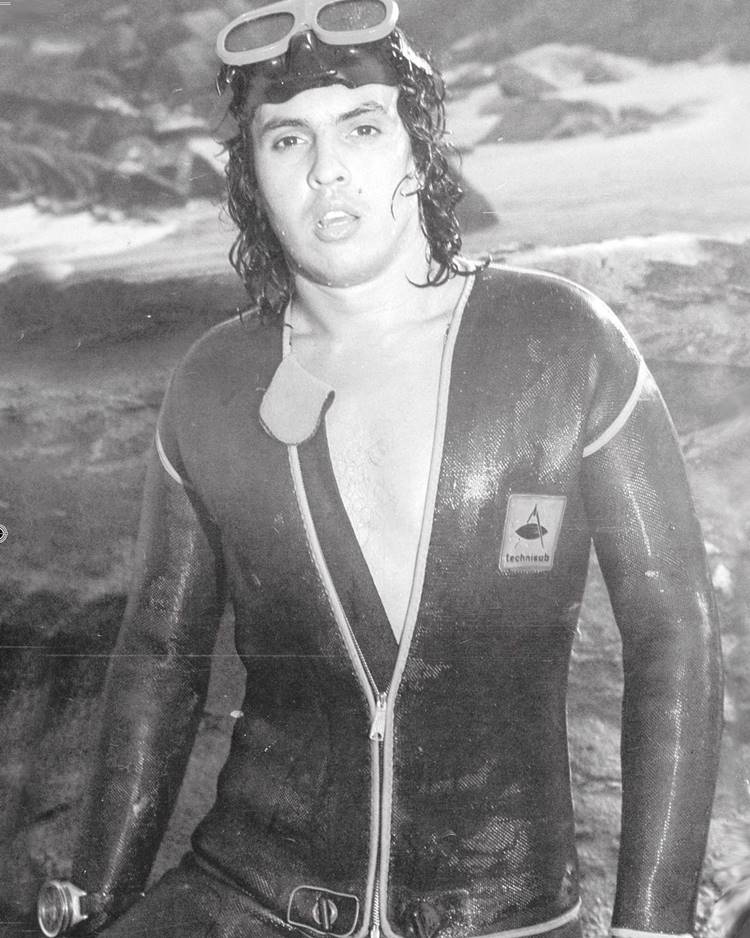Cantor em foto antiga preto e branco com roupa de banho no mar