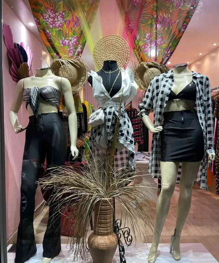 Loja com manequins na vitrine usando roupas com estampa xadrez preto e branco na temática junina