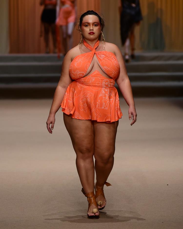 modelo em passarela com peças laranjas, vestido curto