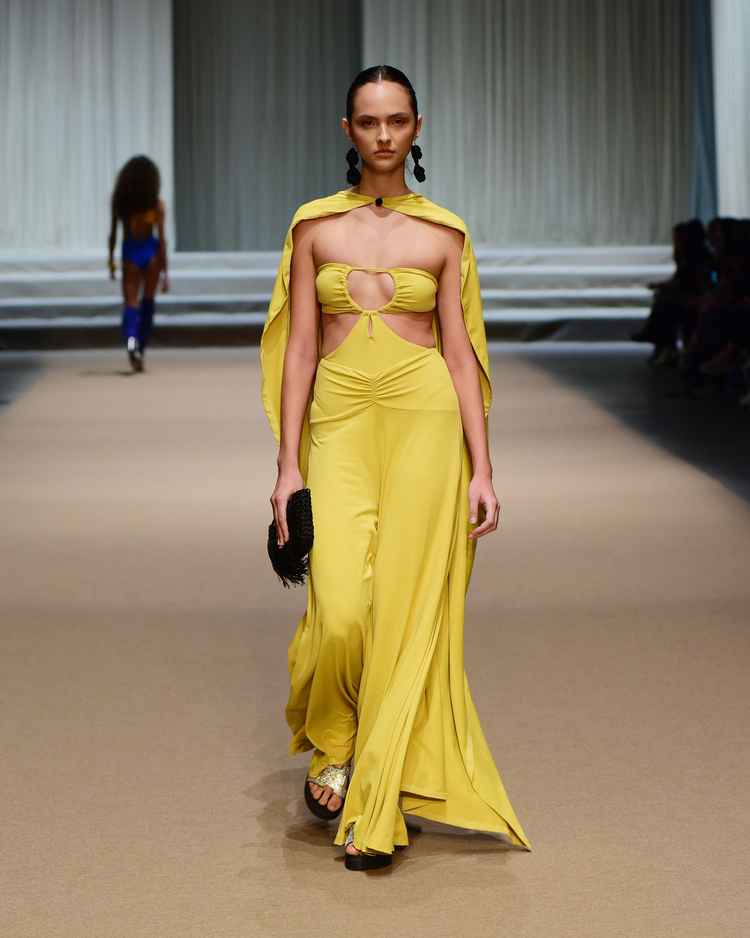 modelo em passarela com vestido longo amarelo