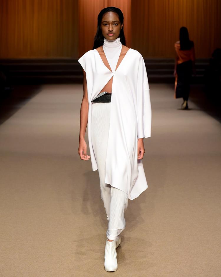modelo em passarela com vestido longo branco com recortes