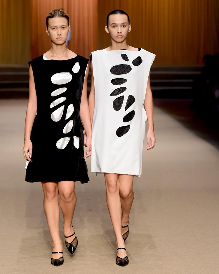 duas modellos com vestidos de cores invertidas, preto e branco
