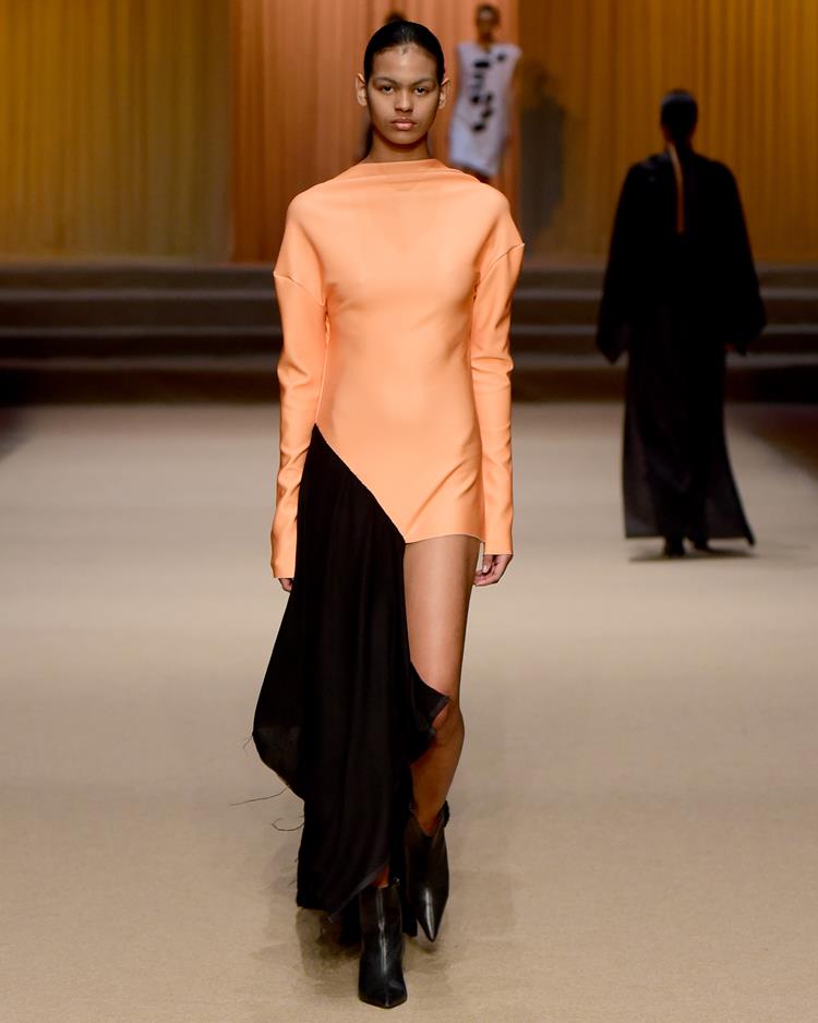 modelo em passarela com vestido longo laranja e preto