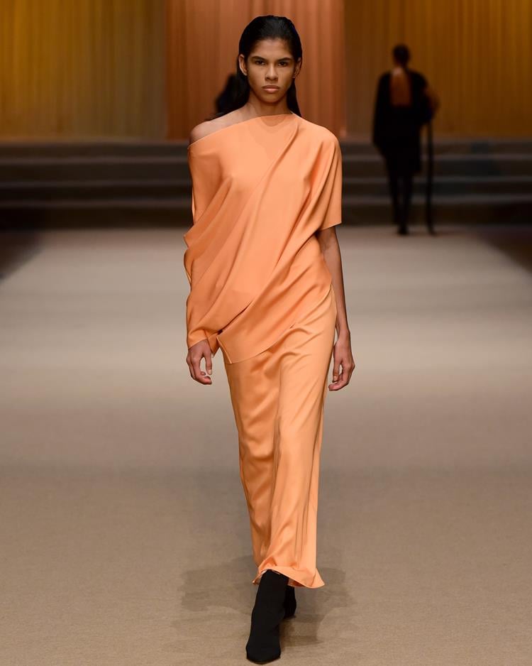 modelo em passarela com vestido longo laranja