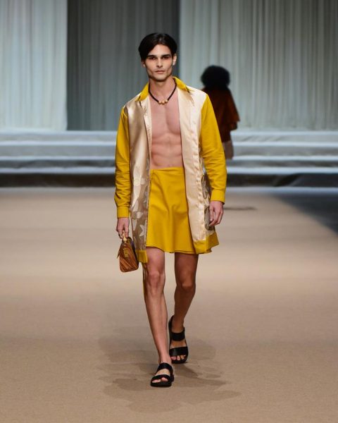 modelo com shorts e blazer amarelos com detalhe dourado