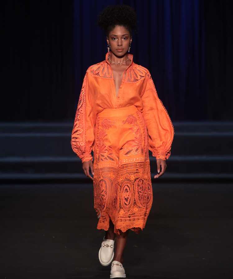 Modelo com macacão laranja rendado no desfile de Almerinda Maria no DFB Festival 2023