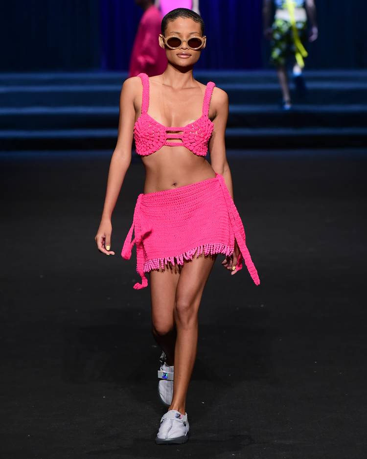 Modelo com top biquíni pink crochê + saia crochê com miaçngas no desfile de David Lee no DFB Festival 2023