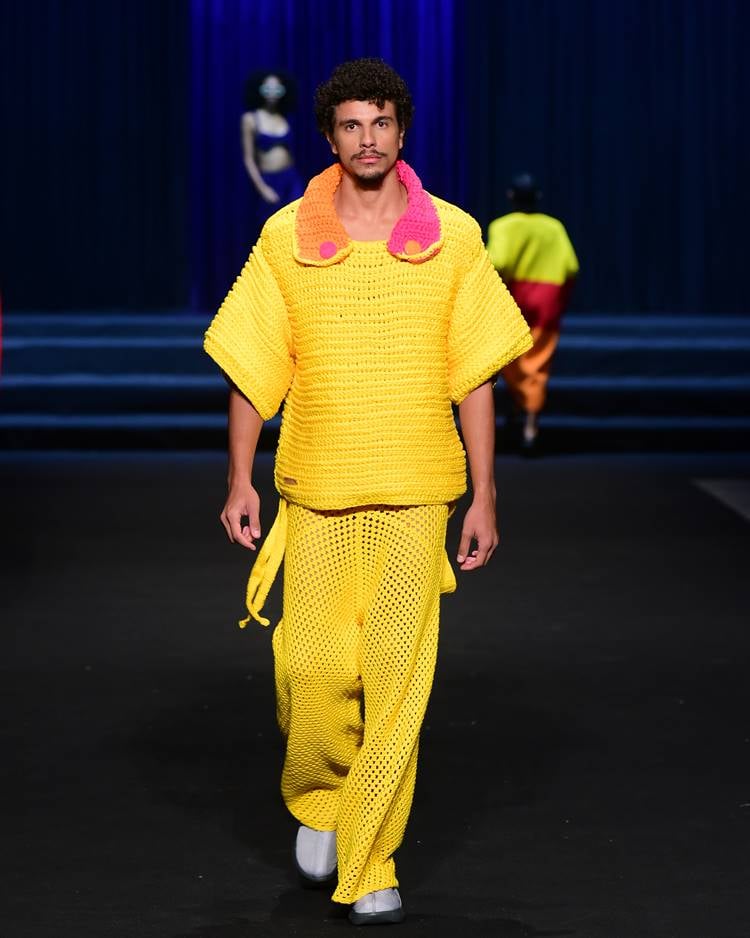 Modelo com camisa em crochê de inverno + calça em crochê amarelo em desfile no DFB Festival 2023