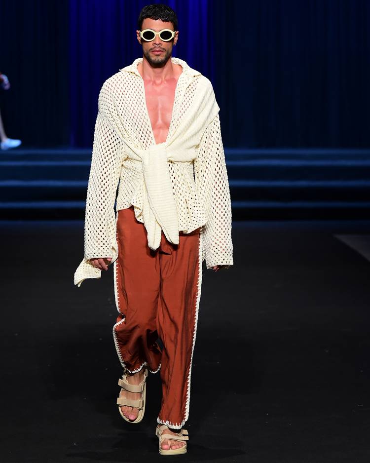 Modelo com roupão branco em crochê + calça cor terra com detalhes em crochê em desfile no DFB Festival 2023