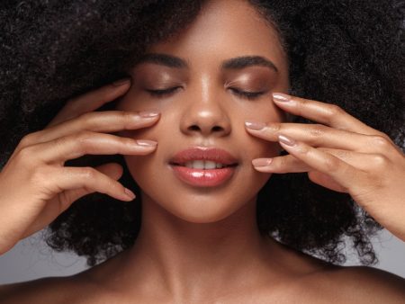 Mulher negra bonita de olhos fechado com as mãos no rosto