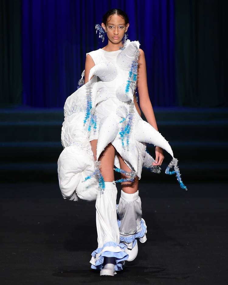 Modelo com vestido branco com detalhes azul no desfile da IFRN no DFB Festival 2023