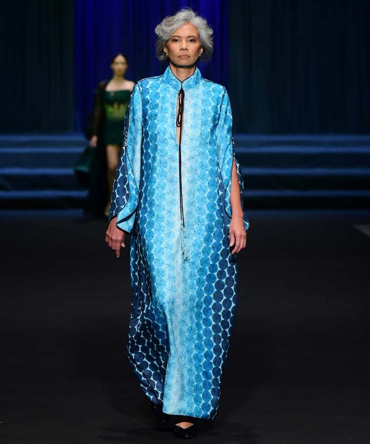 Modelo com vestido azul estampa fuxico em desfile no DFB Festival 2023
