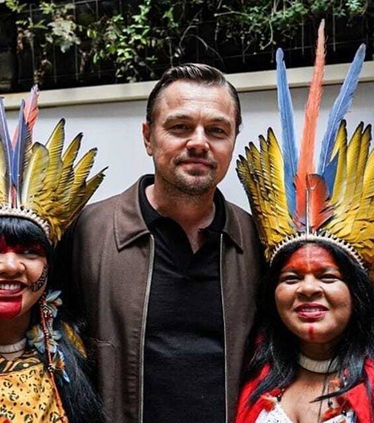 Ator Leonardo DiCaprio hoje em dia, ao lado de população indígena 