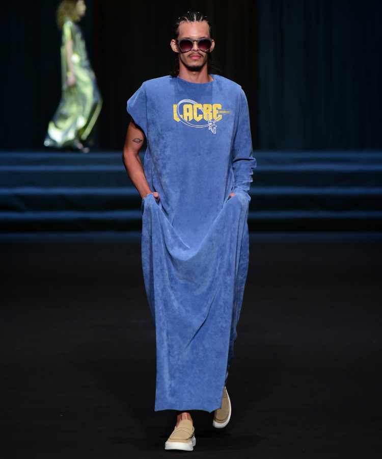 Modelo usando vestido azul jeans com estampa de palavra no desfile de Linbebergue no DFB Festival 2023
