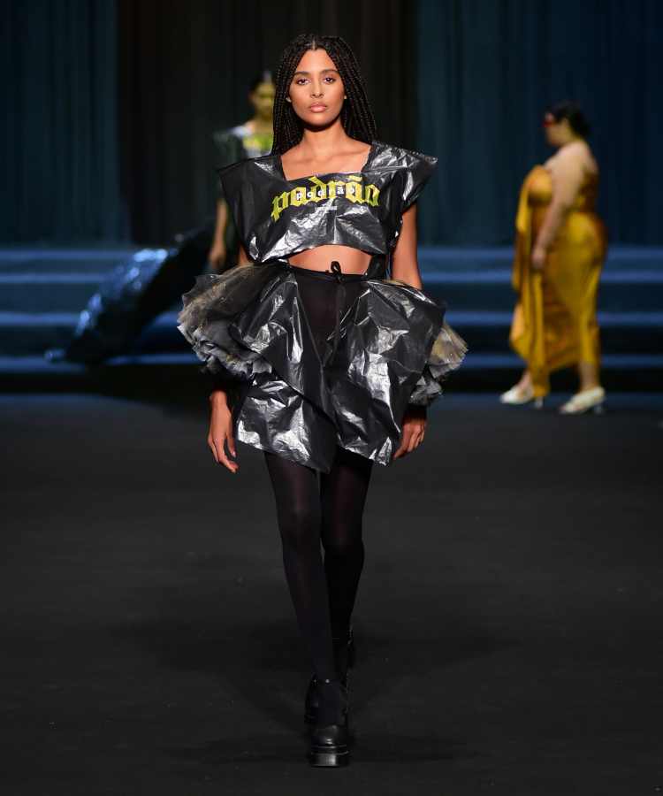Modelo usando cropped + saia de saco preto + meia calça transparente no desfile de Linbebergue no DFB Festival 2023