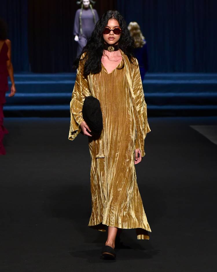 Modelo com vestido dourado em camurça no desfile de Marina Bitu no DFB Festival 2023