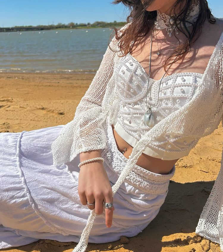 menina na praia com roupa branca estilo mermaidcore