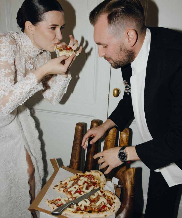 Noivos comendo pizza em casamento
