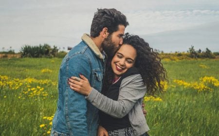 foto de casal de namorados se abraçando em campo de flores amarelas