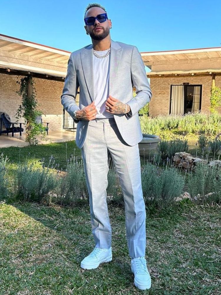 foto de Neymar usando óculos de sol corrente prata, camiseta branca, terno cinza e tênis branco