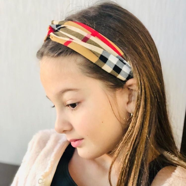 Criança de pele clara usando bandana xadrez no cabelo solto 