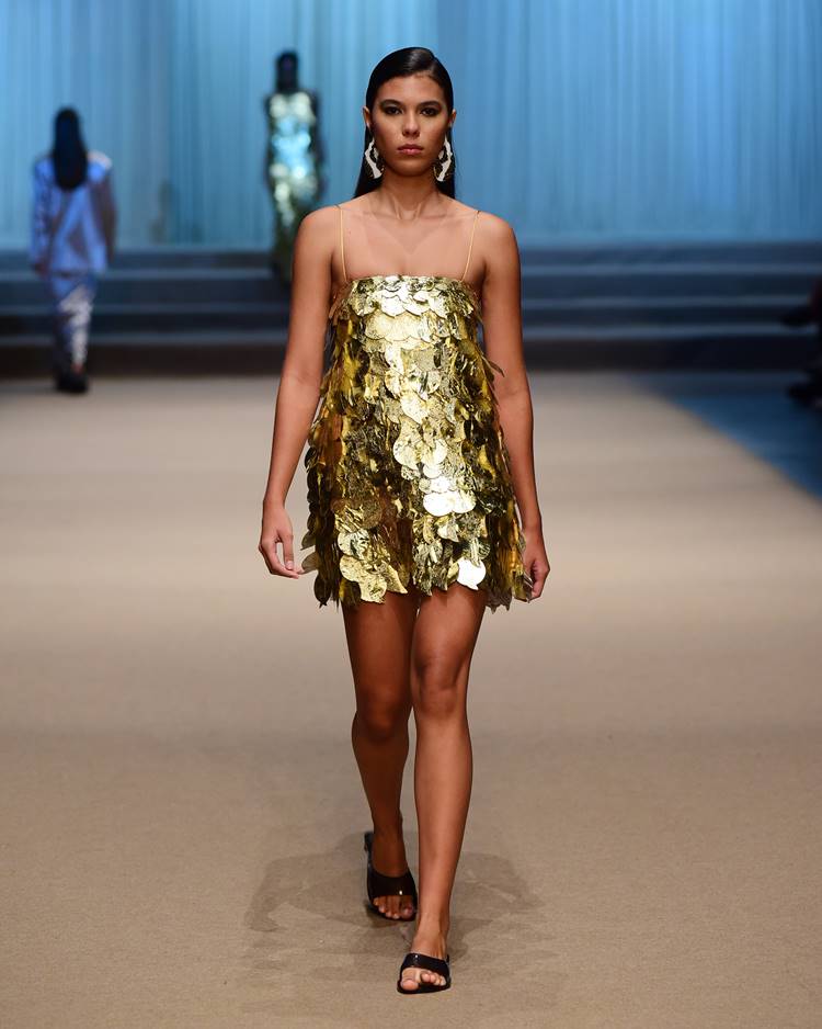 Modelo com vestido curto em lantejoulas macros dourado no desfile da Sau Swin + Sheila Moraes no DFB Festival 2023