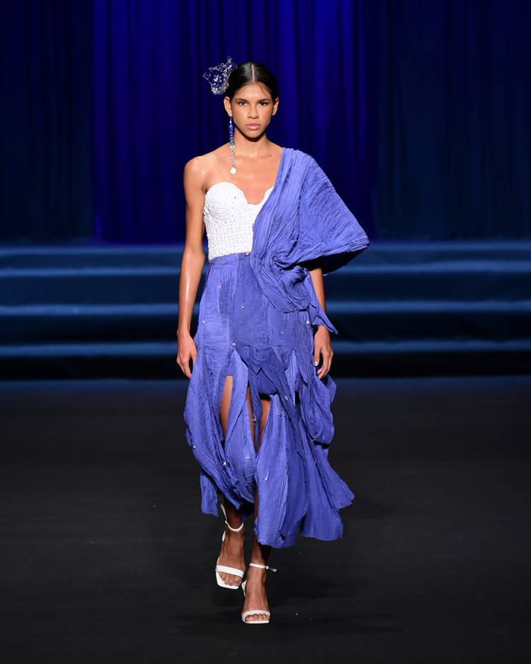 Modelo com cropped branca + saia azul com manga azul no desfile da UNIFOR no Dragon Fashion Brasil Festival 2023
