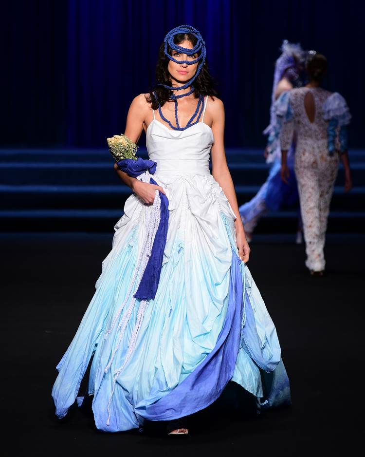 Modelo com vestido de noiva branco e azul no desfile da UNIFOR no Dragon Fashion Brasil  2023