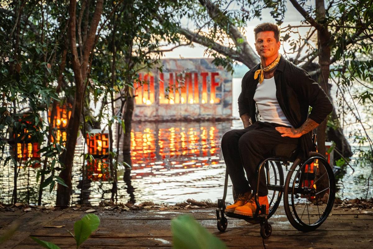 Fernando Fernandes, apresentador de No Limite, em uma cadeira de rodas, na região da Amazônia