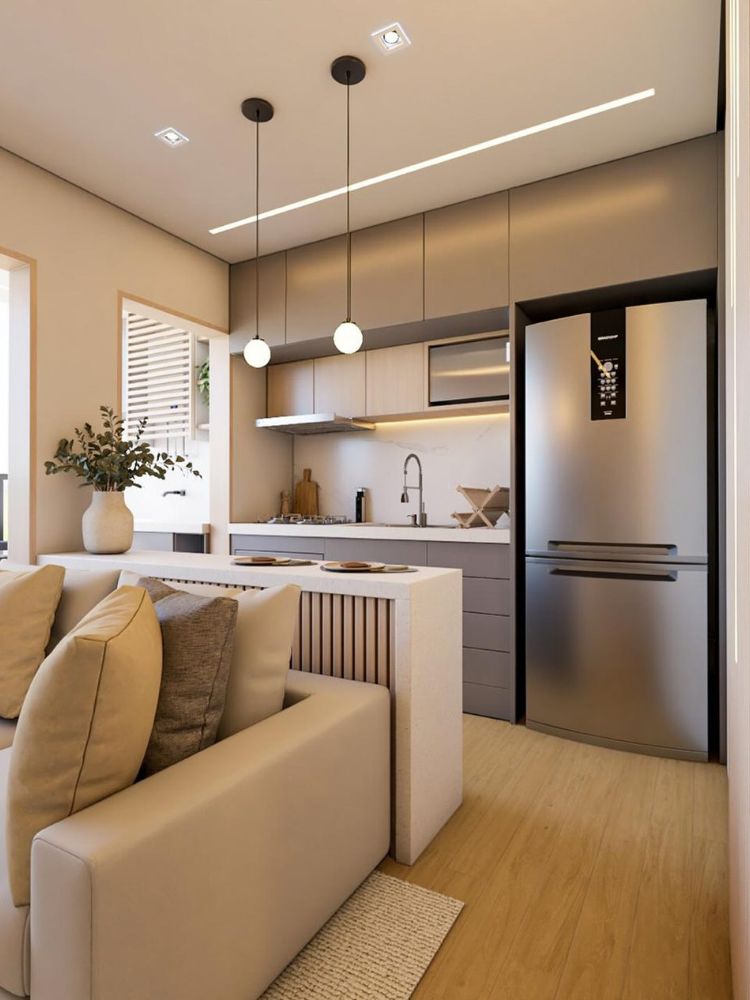 Sala integrada com cozinha, ambas em tons claros e madeira, com pendente sobre bancada de alimentação