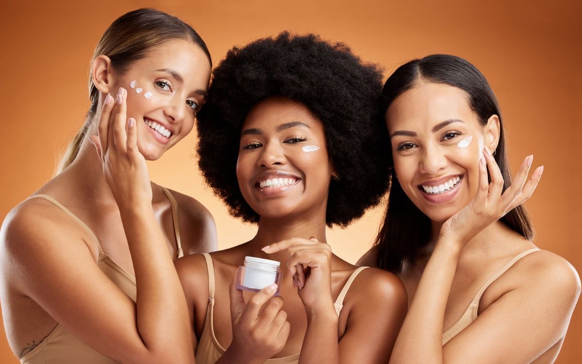 3 mulheres aplicando creme hidratante facial, um dos passos do skincare