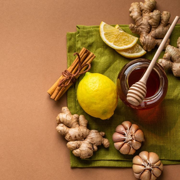 foto de ingredientes como mel, limão e gengibre em fundo marrom