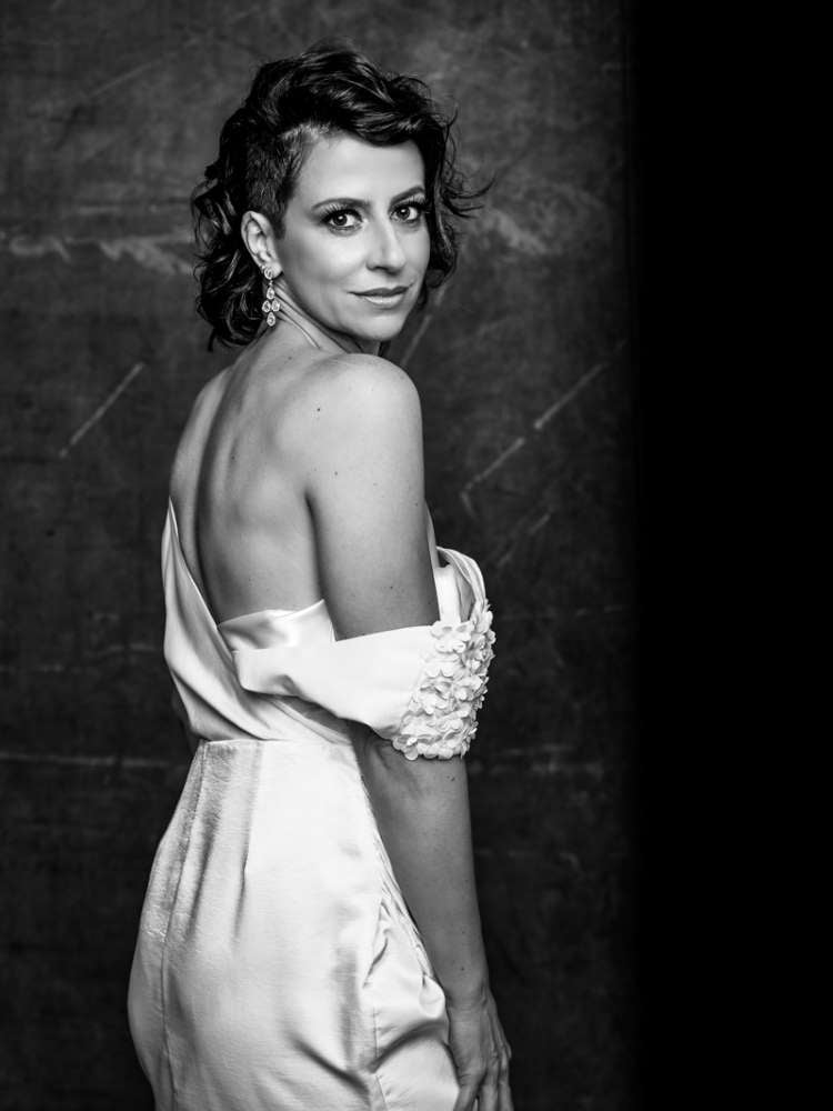 Mulher não-modelo com mais de 40 anos em ensaio fotográfico, usando vestido neutro. Foto preto e branco
