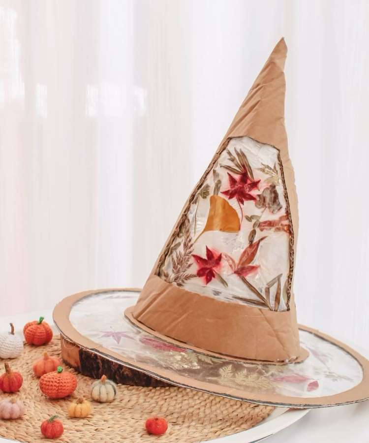 Chapéu de bruxa feito de papelão, plástico e folhas de árvore