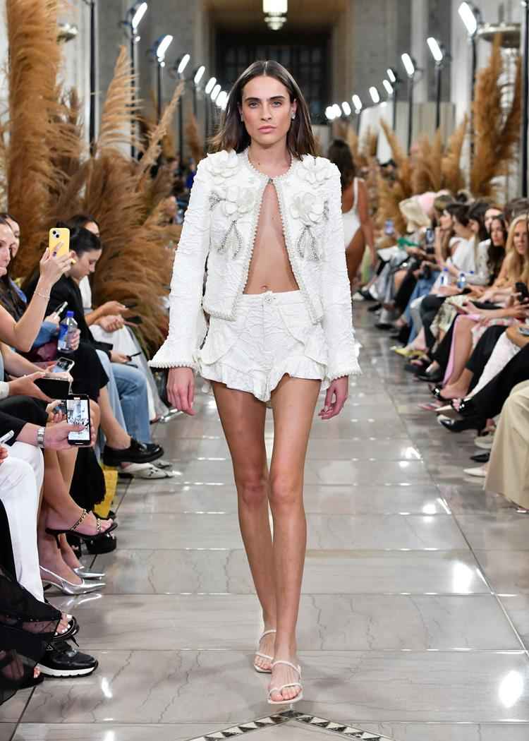 modelo com conjunto branco de jaqueta e shorts curto