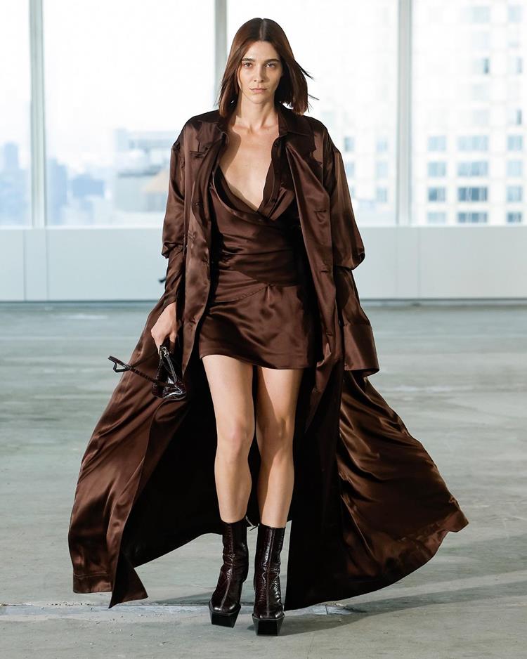 modelo com vestido e casaco longo de mesma cor e tecido, marrom de cetim