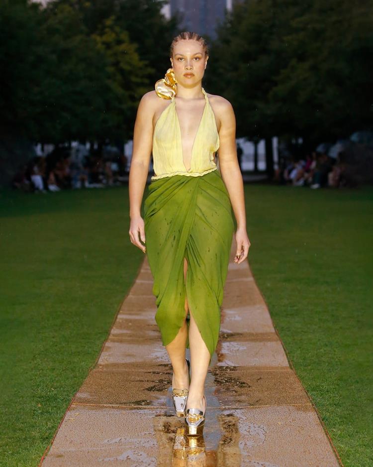 modelo desfilando com saia transparente verde e top amarelo